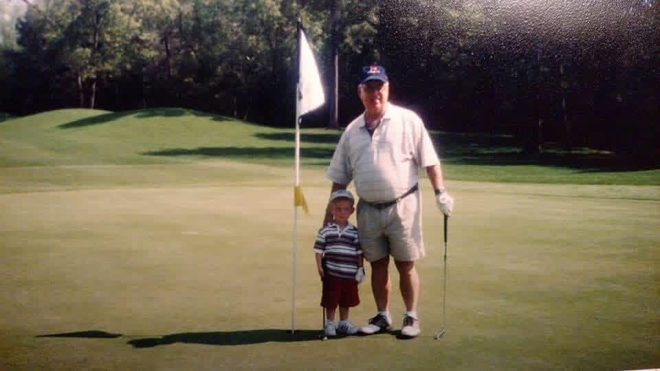 Harry Kenneth Fritz with his grandson on the green at Pawleys Island — a lifetime of early mornings, distilled.